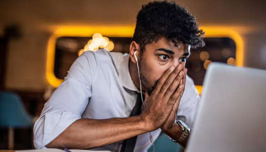 young man sitting in front of his computer screen