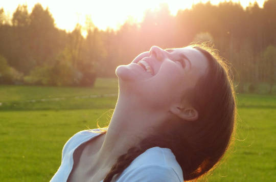young woman with her face turned up towards the sun
