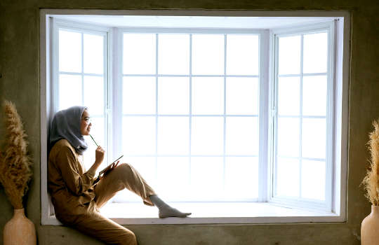 a woman sitting in a bay window