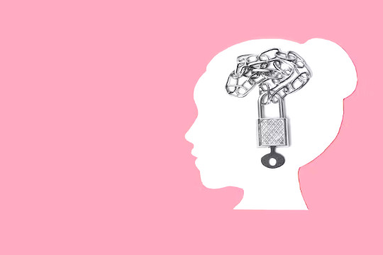 outline of a woman's head with a chain and padlock inside