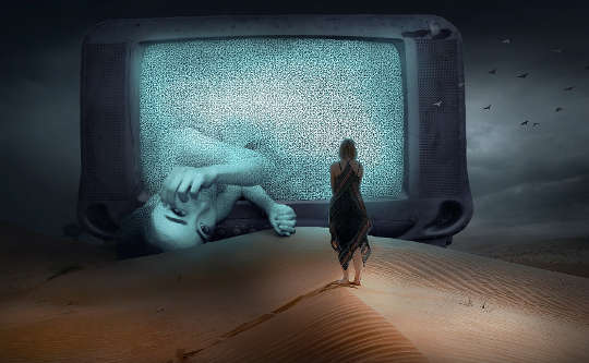 a tv screen in the desert with a woman standing in front and another half-way out of the screen
