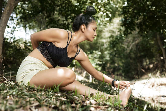 a woman in a seated yoga pose outside in nature