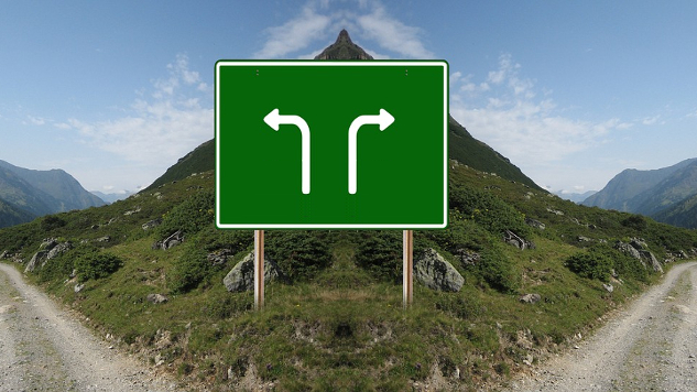 a sign on a road with arrows pointing in different directions: left or right