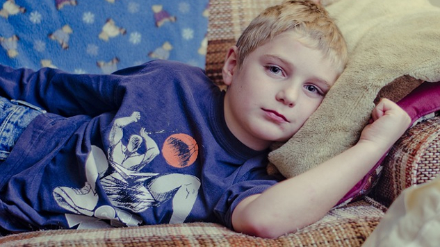 young boy laying on a couch