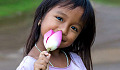 young girl holding an unopened lotus bloom